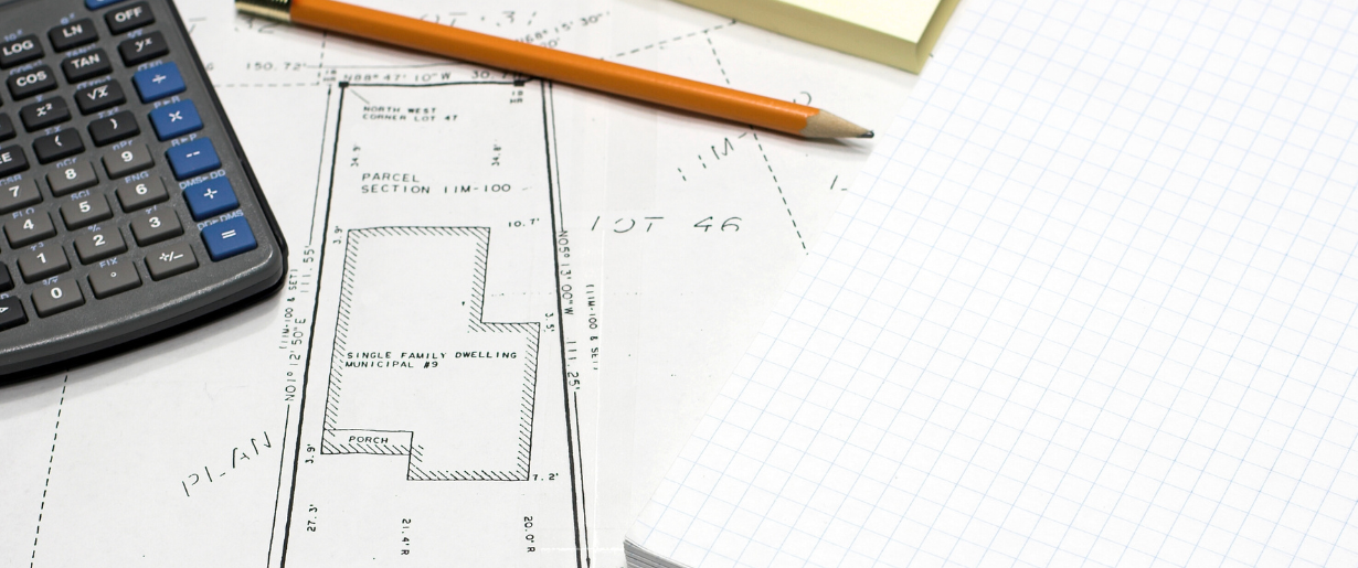 Plan de maison, calculatrice et crayon