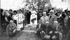 Group of political representatives gathered around the monument