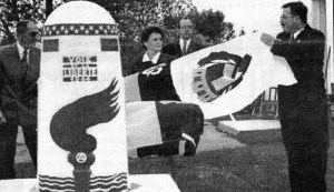 Trois représentants politiques de la France tirant un drapeau pour dévoiler le monument symbolique offert.