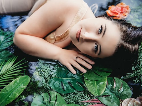 femme allongée dans l'eau à côté d'une fleur de lys