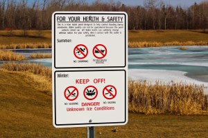 Danger Warning Sign Next to a Storm Drainage Pond
