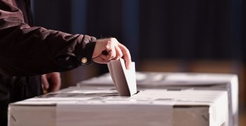 Man dropping ballot into box