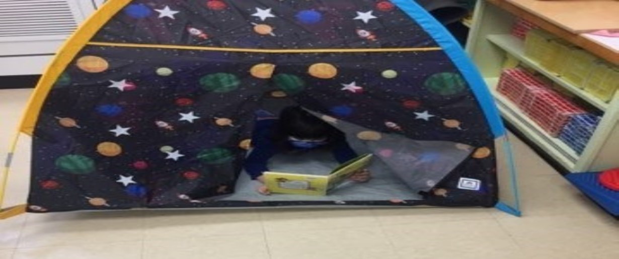 Child reading in a tent
