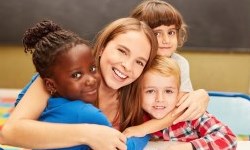 daycare staff hugging three children