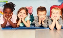 four kids on the floor smiling