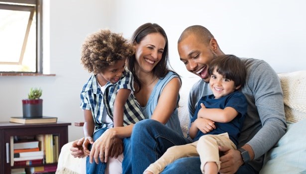 Famille assise sur un sofa et se souriant les uns aux autres